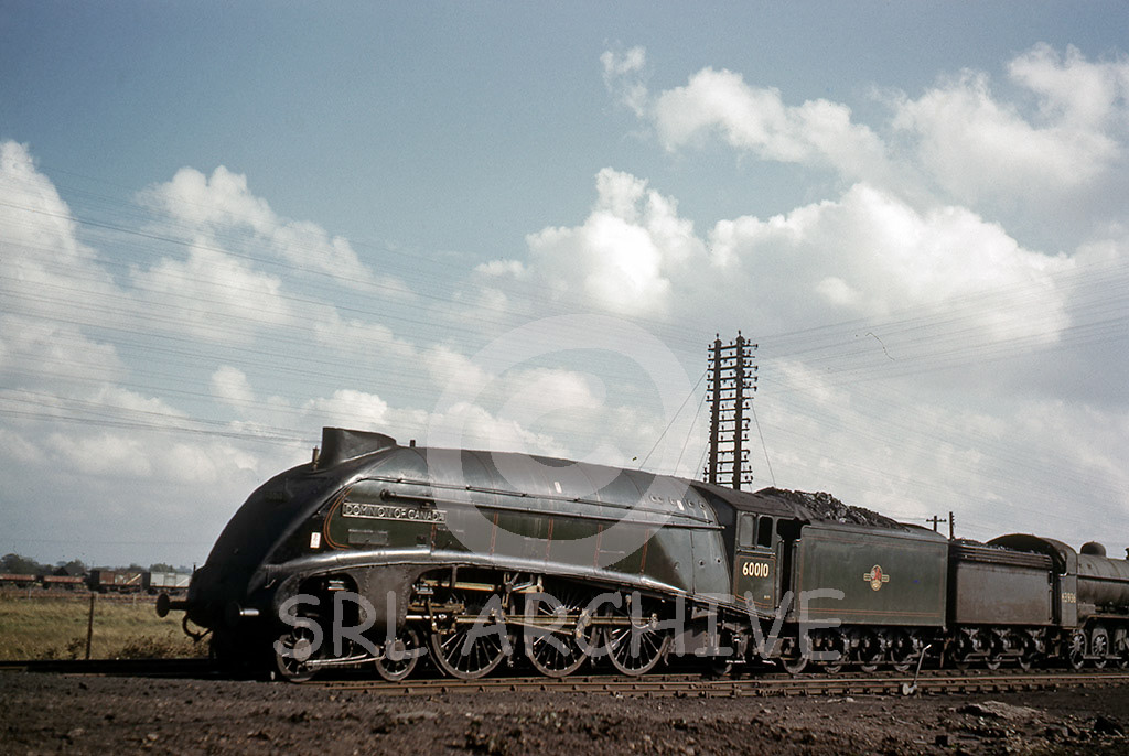 60010 'Dominion of Canada' in the yard at Doncaster 5th March 1962 during a works visit behind is 02 Class No 63936 SRL No 97 