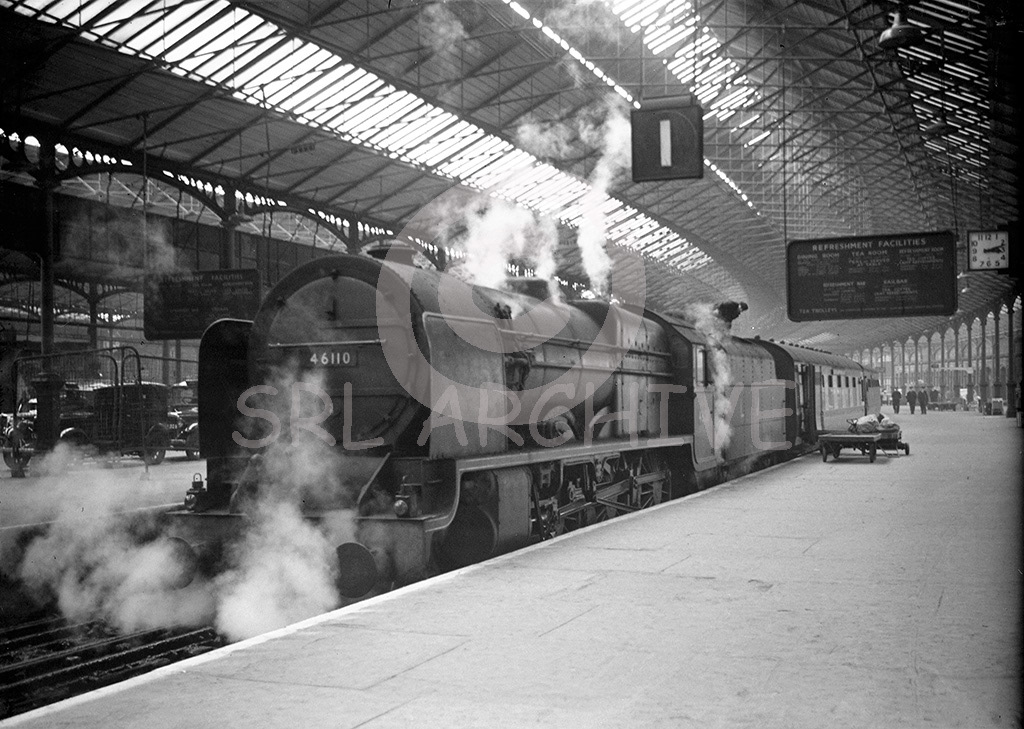 Stanier LMS Royal Scot Class 4-6-0 No 46110 'Grenadier Guardsman' after arrivla from the north into London Euston station with the station clock showing 3.12pm around 1950-51. On the far left plenty of taxis await passengers for the next journey into the capital. SRL No 215 