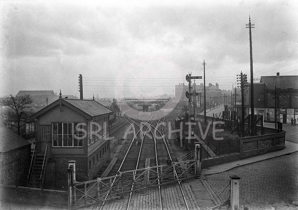 Looking towards Altrincham & Bowdon railway station sometime between 1930-50. Altrincham North signal box on the left a LNWR Type 5 design with 72 levers. Seen here before the corner of the box was altered to allow a clear view of the busy Stockport Road level crossing which the box controlled. Opened in 1908 the box survived until closure in 1991. The station was opened in 1881 on the site of a former station by the Manchester, South Junction & Altrincham Railway. One of a set of glass negatives taken by amateur photographer George John Drysdale who came from the Seaforth area of Liverpool. Born in 1874 in Liverpool, never married and worked as a telephone electrician for the GPO, died in 1948. He was not just interested in the railway but living in Liverpool had the docks and took some superb plates of the RMS Mauretania. George John Drysdale/SRL No 202 