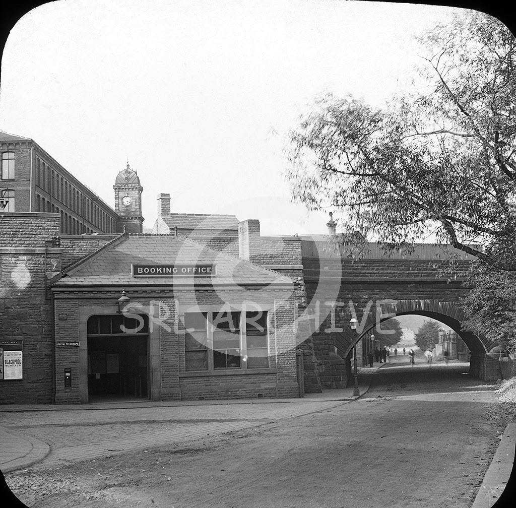 The front entrance to Elland railway station near Brighouse, West Yorkshire showing the Booking Office. On the front of the main building we see the Lancashire & Yorkshire Railway notice board have some posters advertising excursions to Blackpool. The station closed in 1962 but plans are well under way by Calderdale council to build a new Elland station with completion in 2026. SRL No 434 