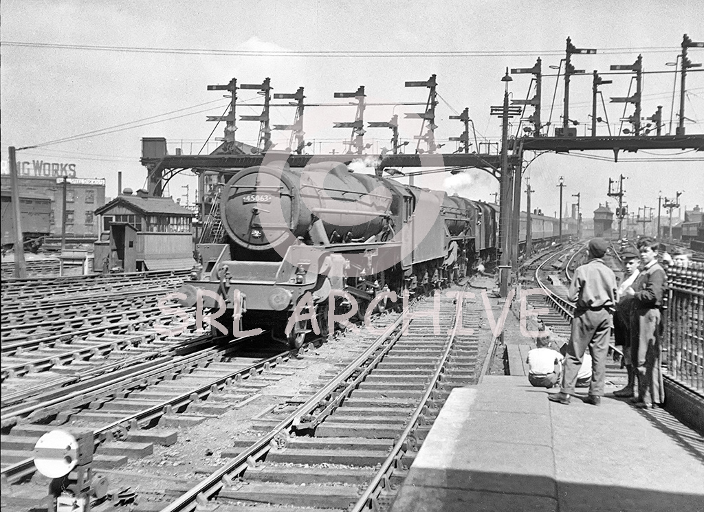45063 + ? arriving into Manchester Victoria station around 1951 watched by some young spotters and some wonderful signal gantries SRL No 596