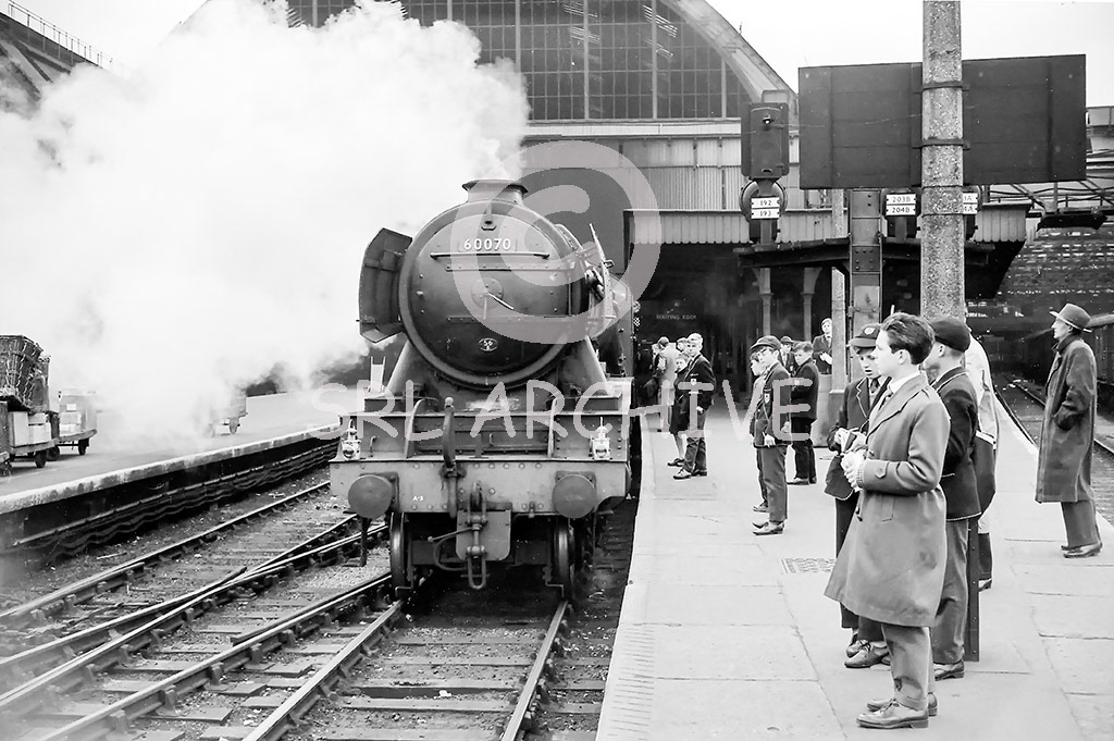 60070 'Gladiator' gets much attention waiting to depart from London Kings Cross station for the north early 1960's SRL No 1117 