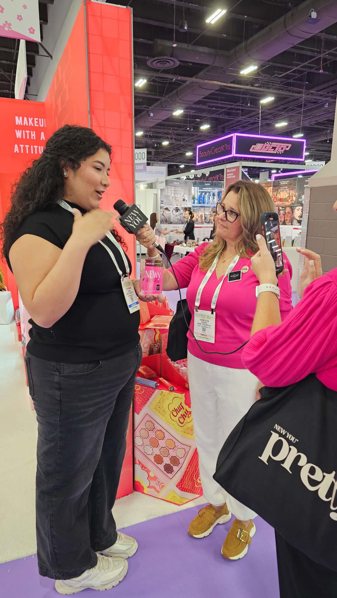 Our Social Media Team Lead, Stephanie, being interviewed at CosmoProf Las Vegas 2026 after Rude Cosmetics received the "NEWy" Finalist Award for the Rude X Chupa Chups collection which was designed by me.