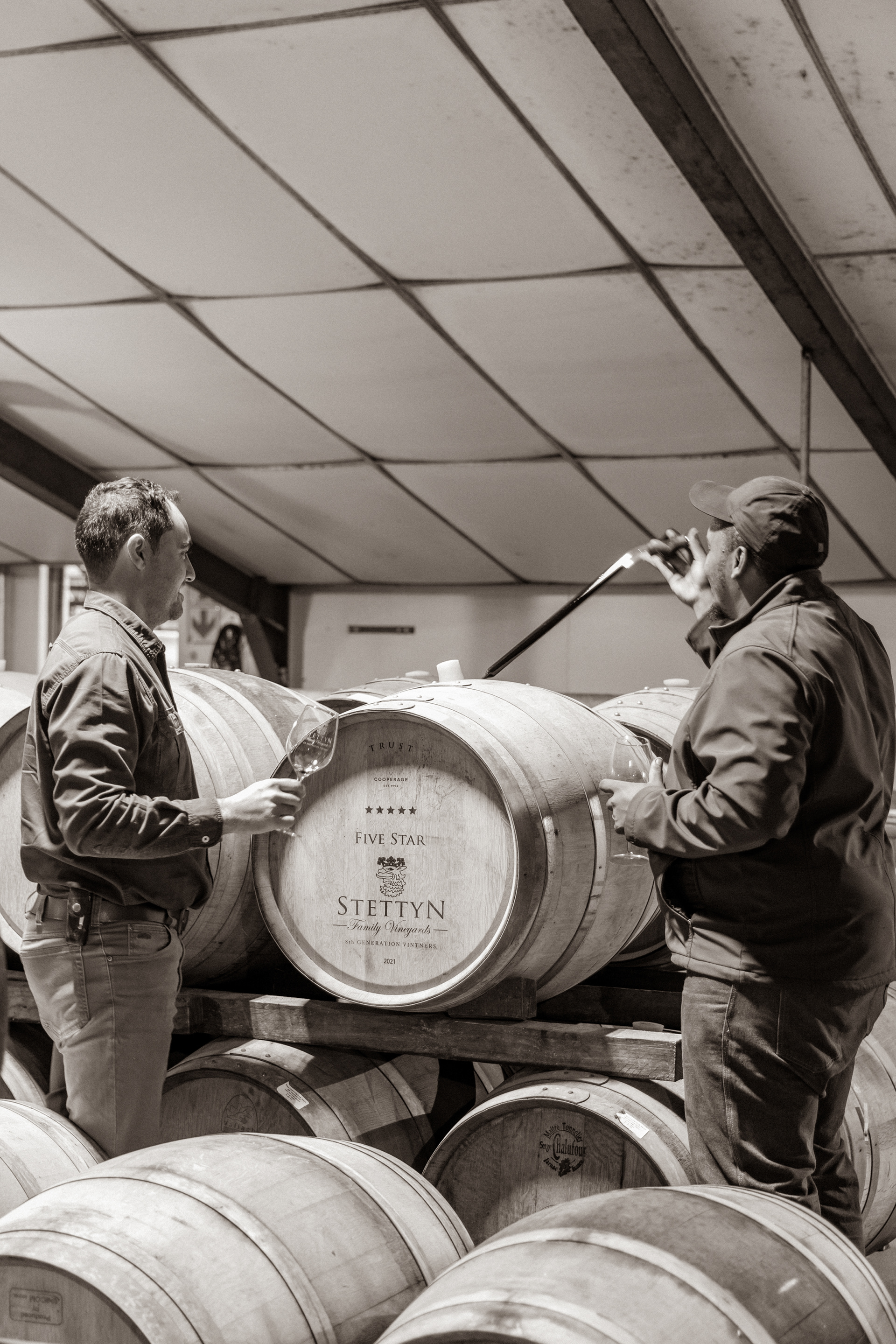 Ronnie carefully extracting a wine sample from the barrel, a crucial step in the winemaking process.