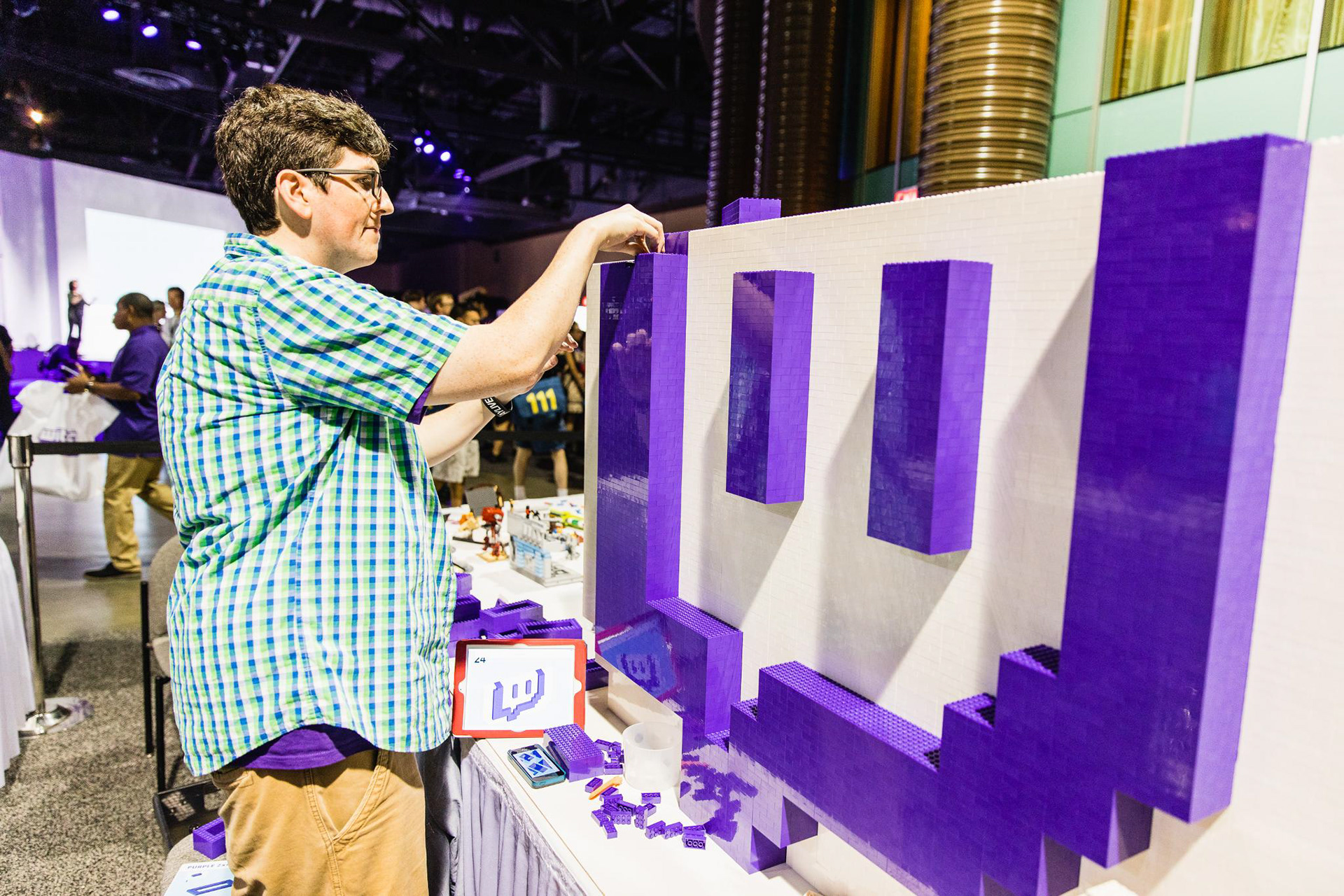 Jonny adding LEGO bricks to the giant model Glitch logo at TwitchCon 2017.