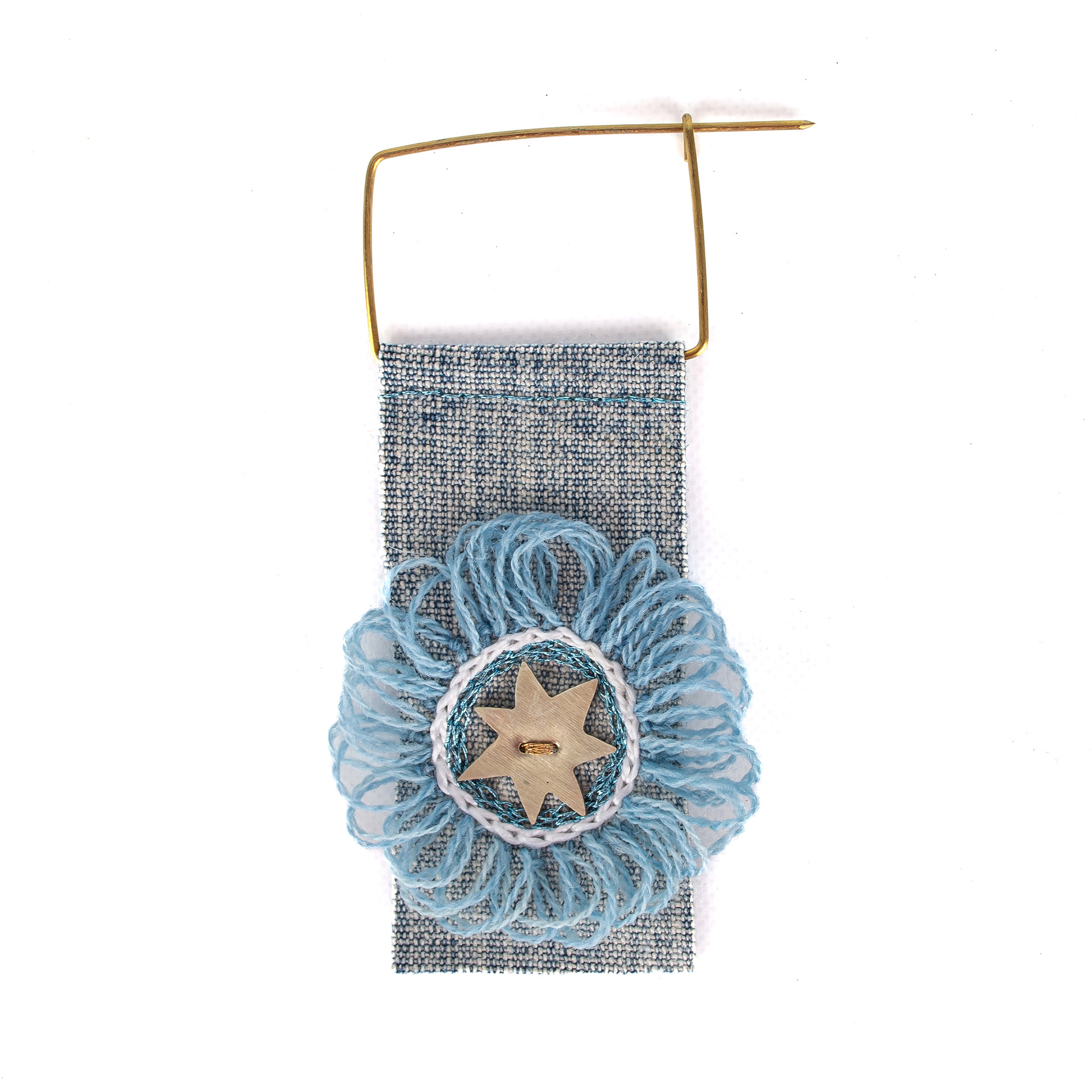 Escarapela bordada a mano, soporte jean, gancho de bronce y estrella de alpaca. $15.000