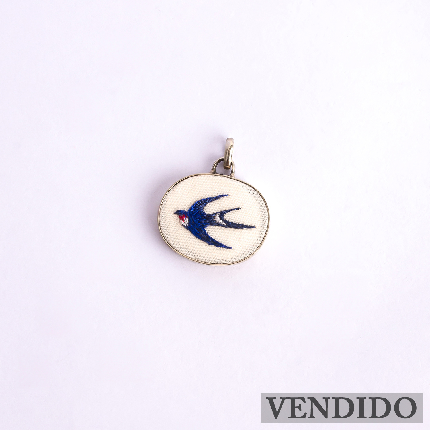 Dije Golondrina. Bordado a mano. Marco de alpaca. Collar de acero quirúrgico. Pieza única. $25.000