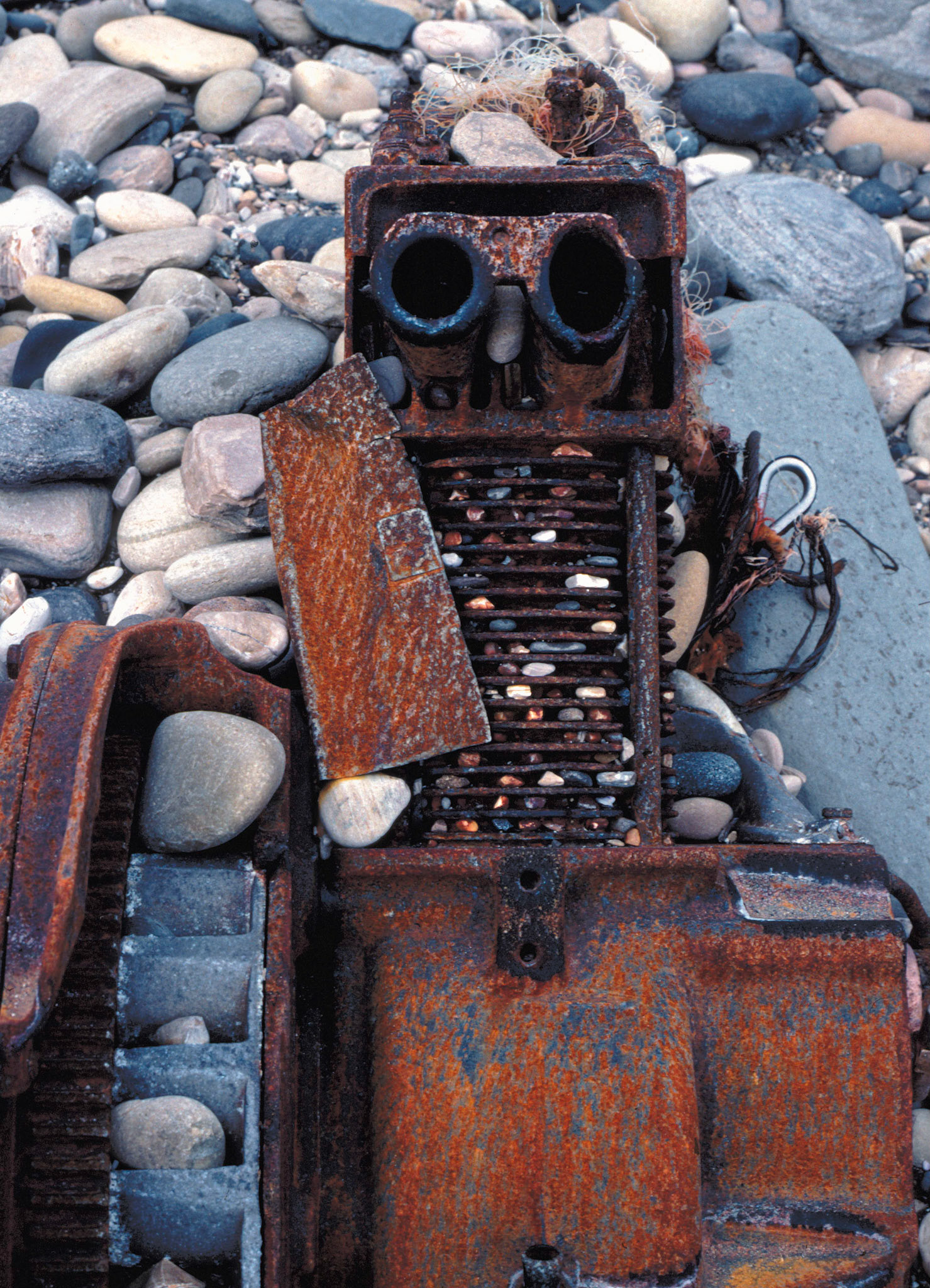 Face on the beach (rusting engine on pebbles), California, 1983