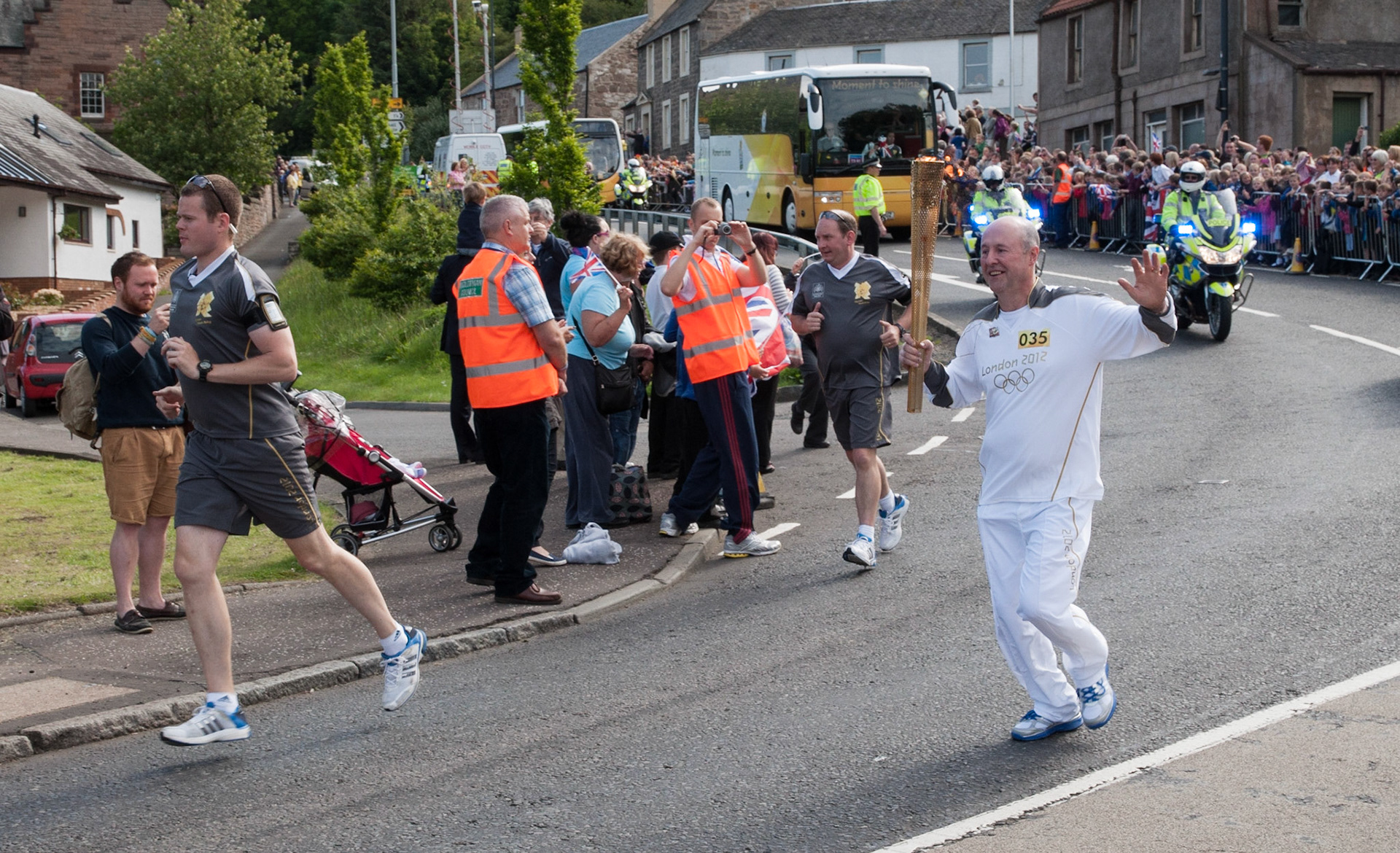 Ivor Mathers carries the Olympic torch through Lasswade, Midlothian, 2012