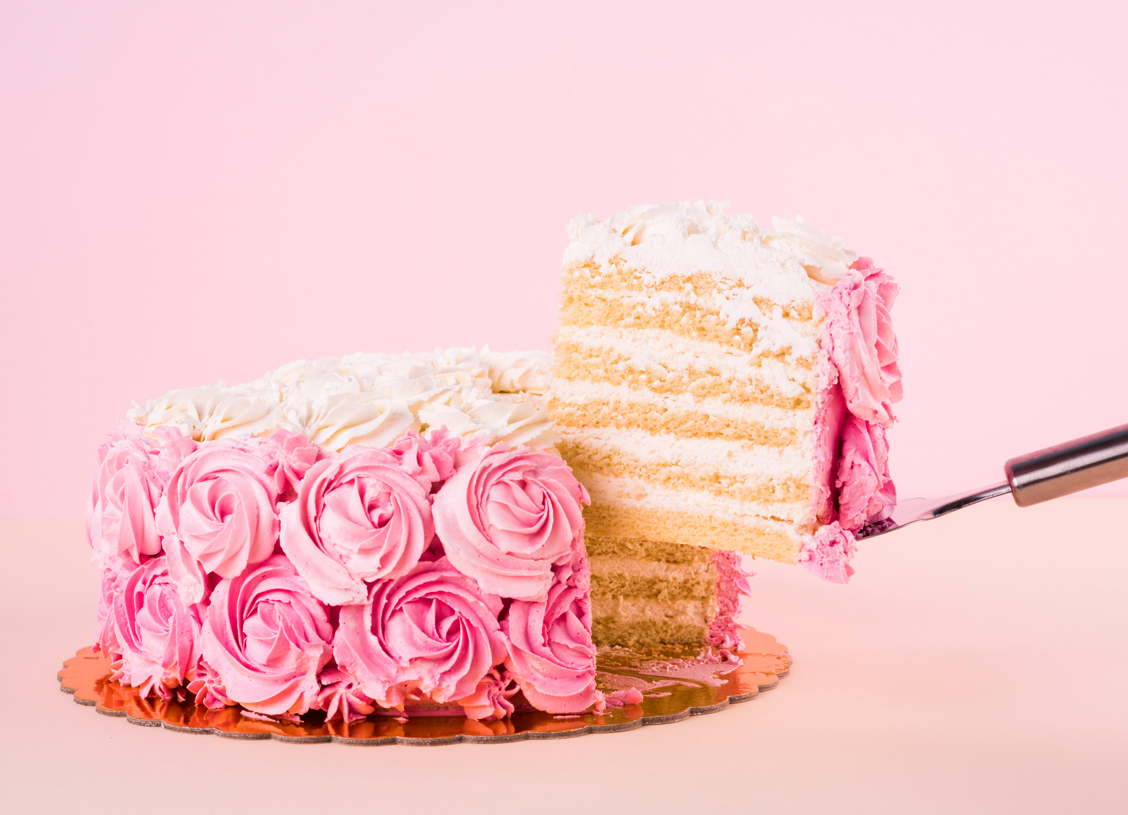 Pink cake with slice being removed