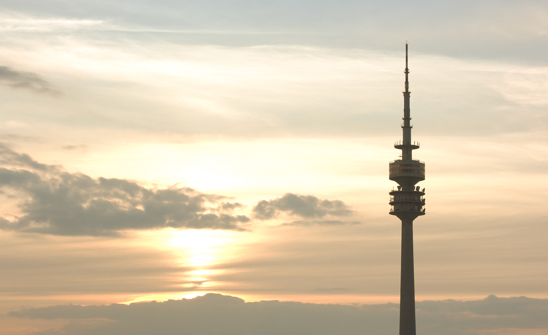 Der Münchner Olympiaturm bei Sonnenuntergang.