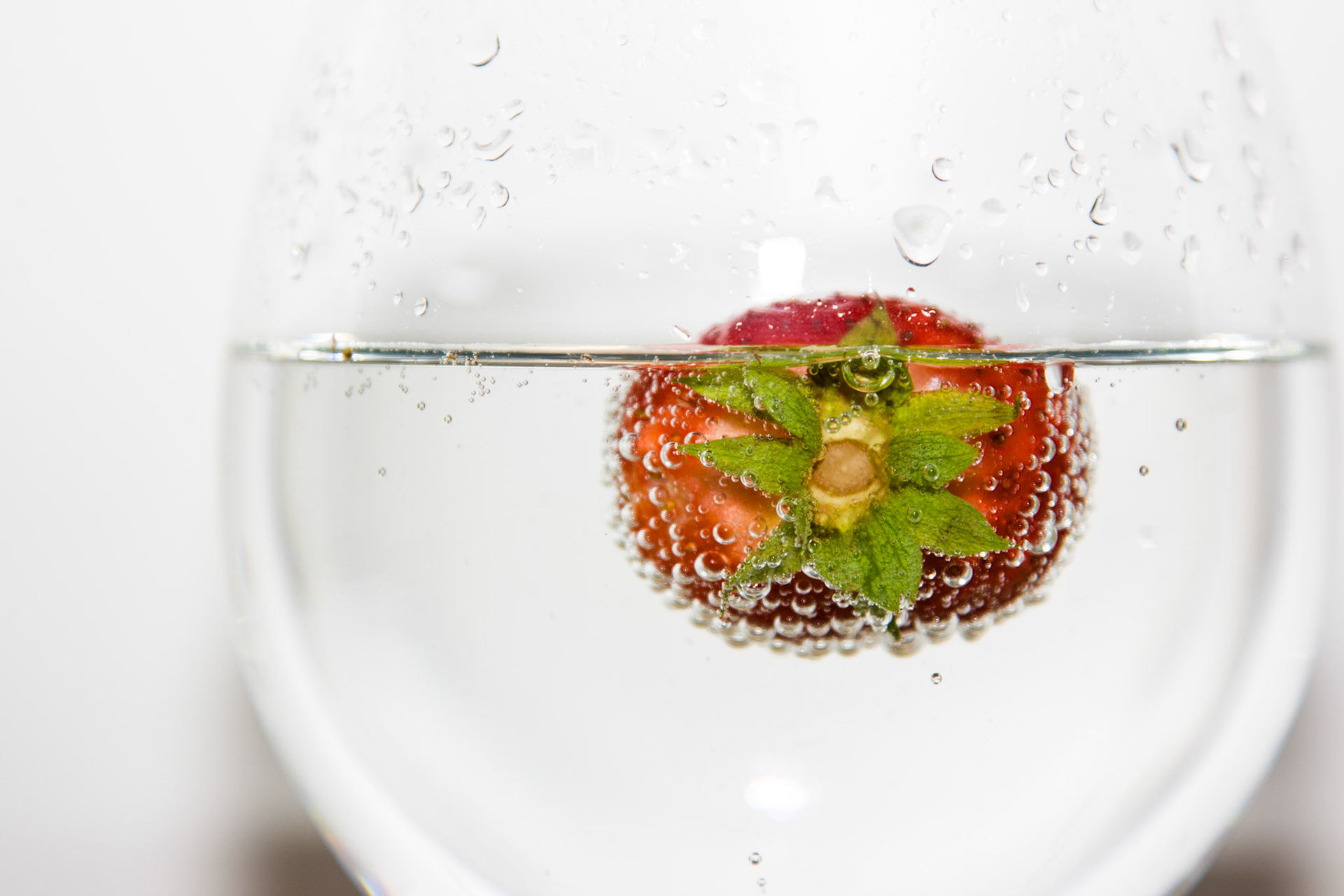 Todesmutig springt diese Erdbeere in eine volles Wasserglas.