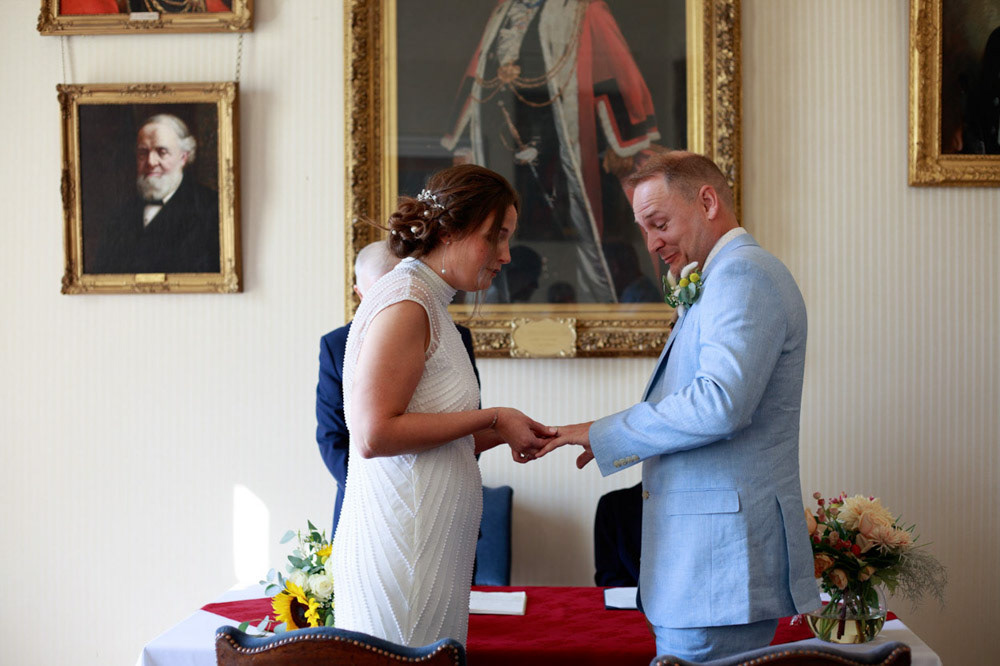 Bride placing the ring on groom’s finger, smiling warmly during ceremony