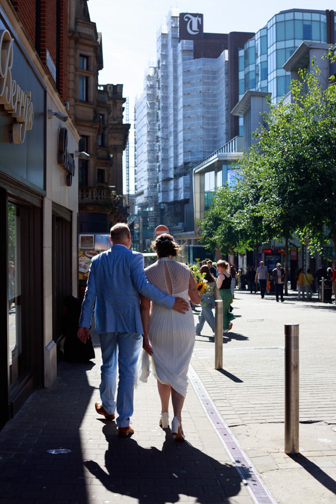 Wedding couple walking through city streets toward Lost & Found Leeds Club