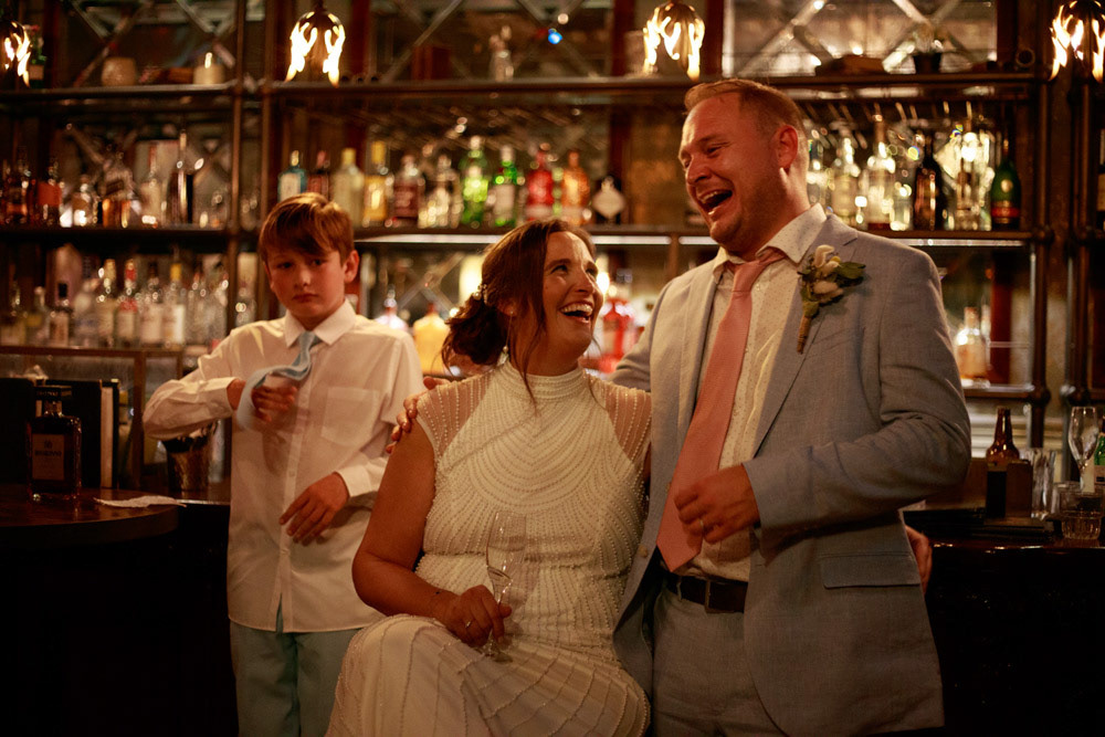 Bride and groom laugh together during the speeches