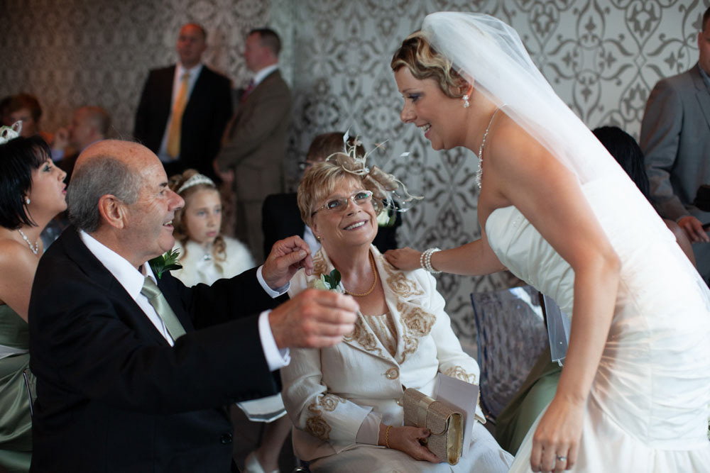 Sam hugs her father with a hand resting on her mother’s shoulder.