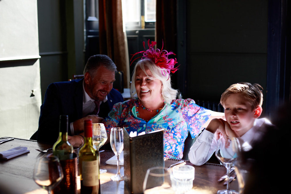 Groom’s parents and son seated at the wedding breakfast