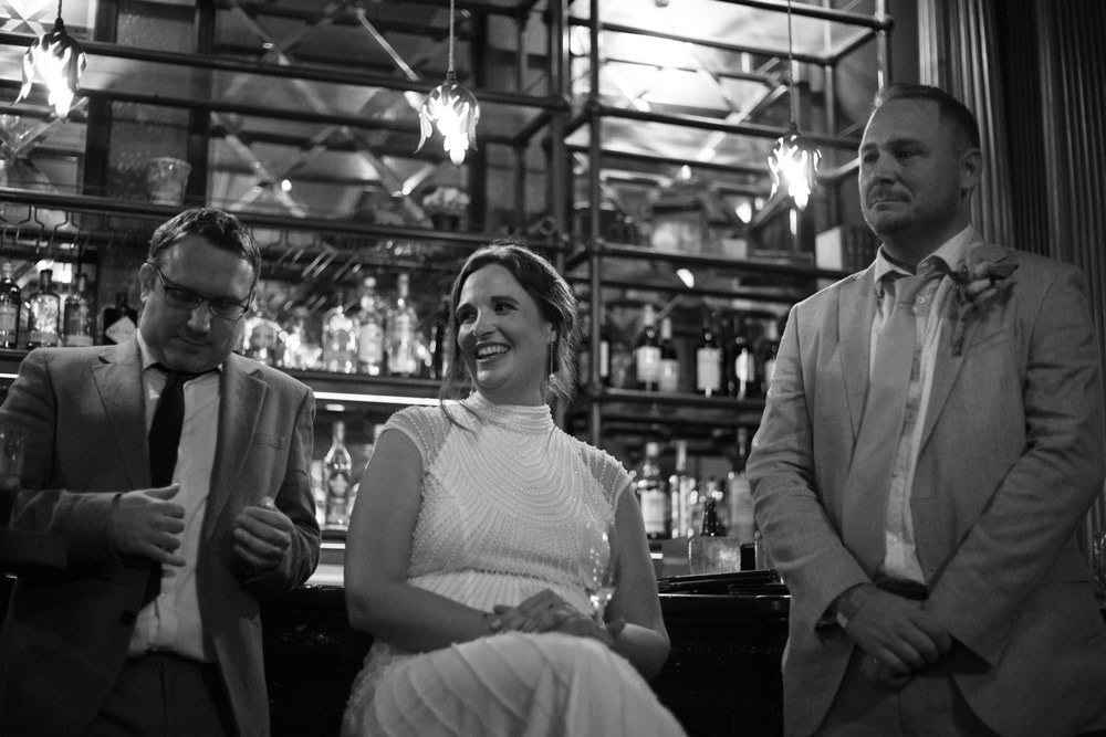 Bride and groom looking on as their son prepares to speak