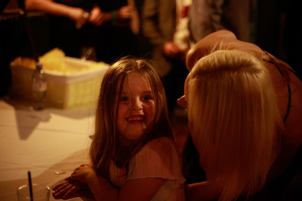 Young girl beaming at her mum during the reception