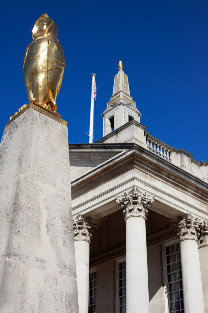 Golden owl glistening atop Leeds Civic Hall against a clear blue sky