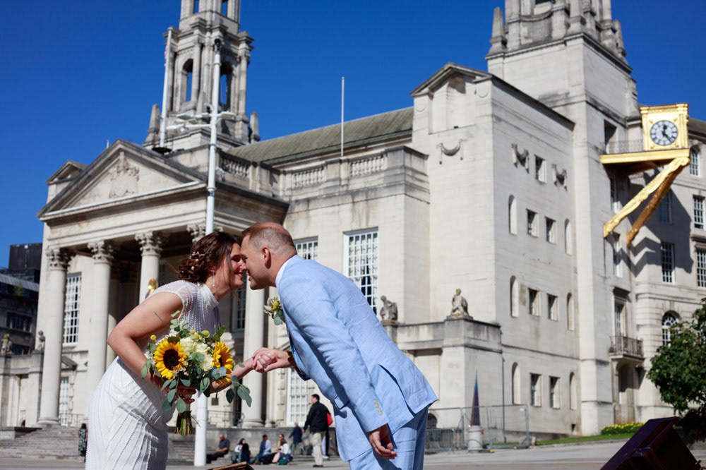 Bride and groom smiling nose to nose outside Leeds Civic Hall