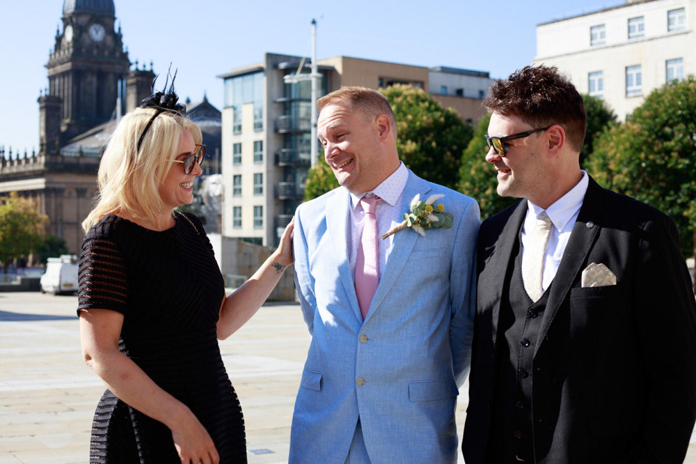 Groom greeting his sister and brother-in-law in the sunshine outside Civic Hall