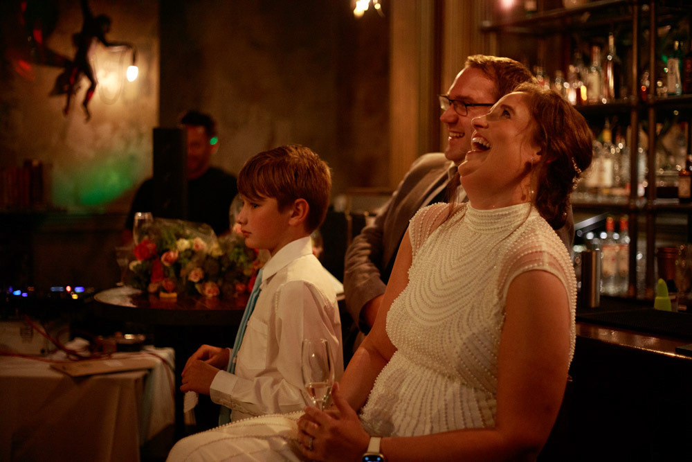 Bride laughing loudly during the groom’s speech