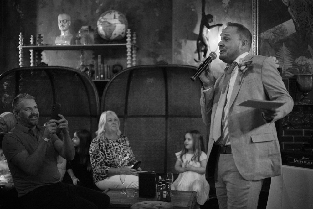 Groom’s father records the speech on his phone