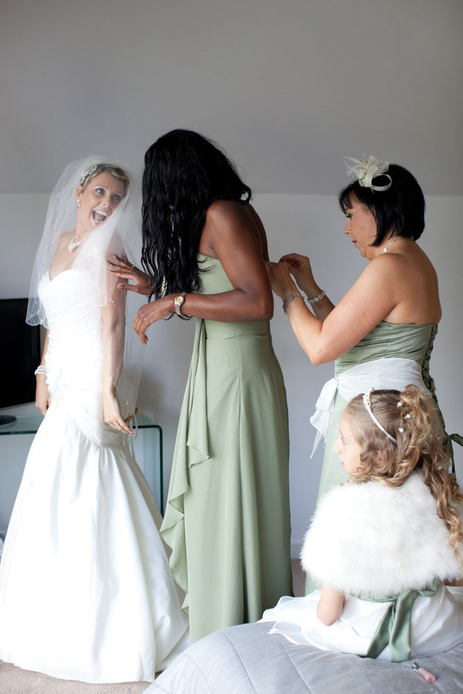 Bride beaming as her close friend arrives during preparations.