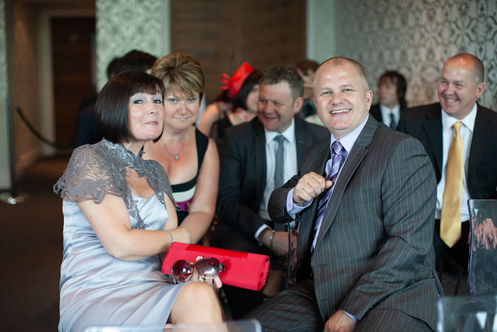 Guests seated and smiling warmly at the camera before the ceremony.