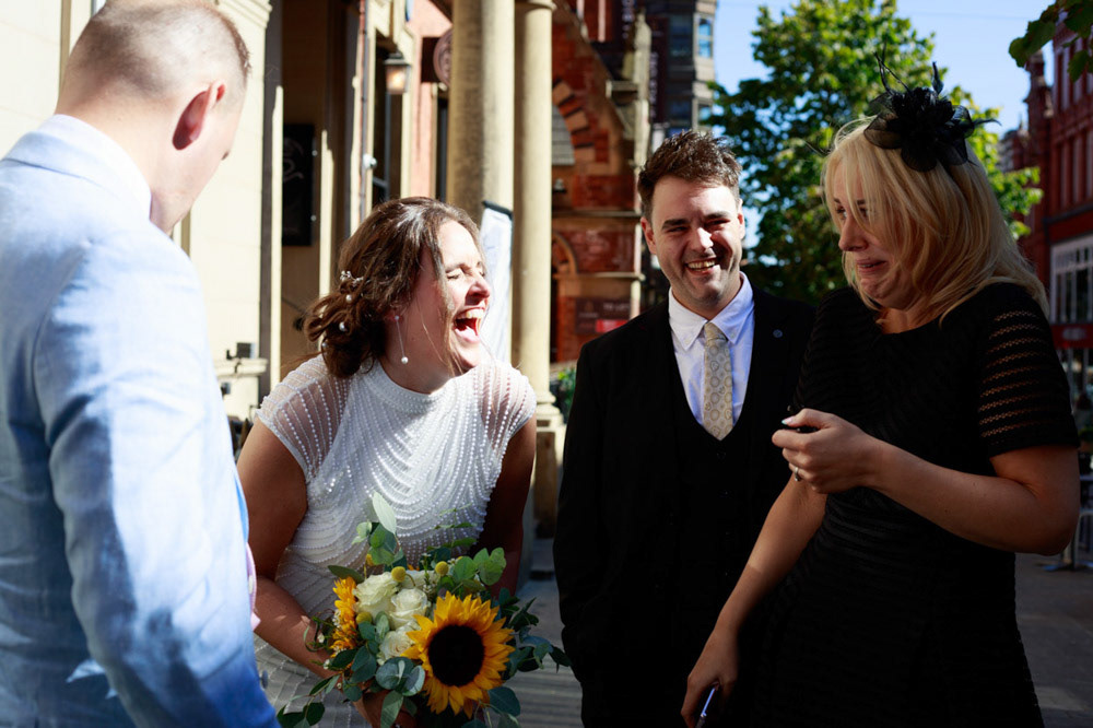 Bride and groom arrive at Lost & Found Leeds laughing with family