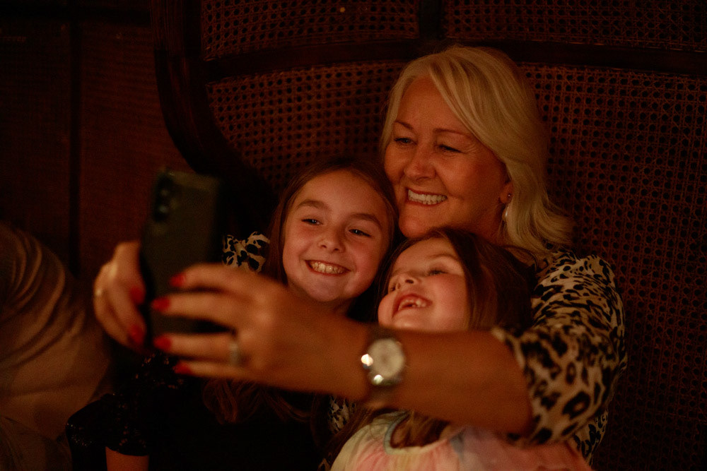 A grandmother takes a selfie with her two grandkids