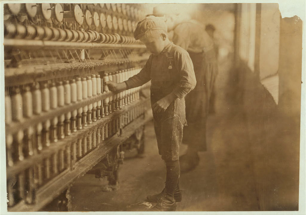 title: Doffer in Mellville Mfg. Co., Cherryville, N.C. Said he had been working for two years. Many of them below age. Location: Cherryville, North Carolina.