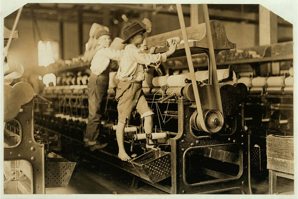 488 Macon, Ga. Lewis W. Hine 1-19-1909. Bibb Mill No. 1 Many youngsters here. Some boys were so small they had to climb up on the spinning frame to mend the broken threads and put back the empty bobbins. Location: Macon, Georgia