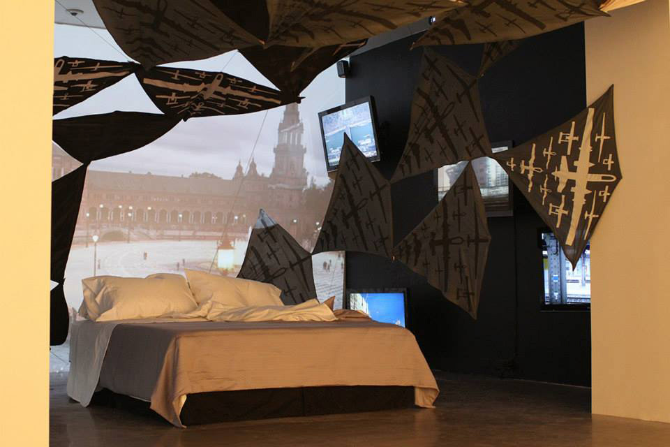 During a trip to Europe, Tomiko Jones and I collected video and audio of unsuspecting people- we looked at it as gathering surveillance footage. We then projected 7  channels of video using projectors and monitors above and around the bed. The drone kites added to the dream-like setting.
