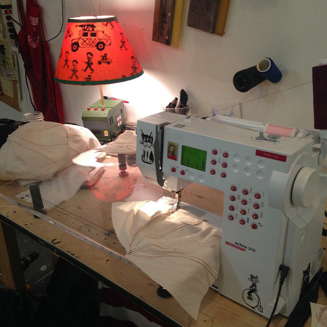 Sewing little parachutes. Paint with 4 coats of gesso to hold their shape when hung. Lamp with painted base and War is Fun! lampshade.