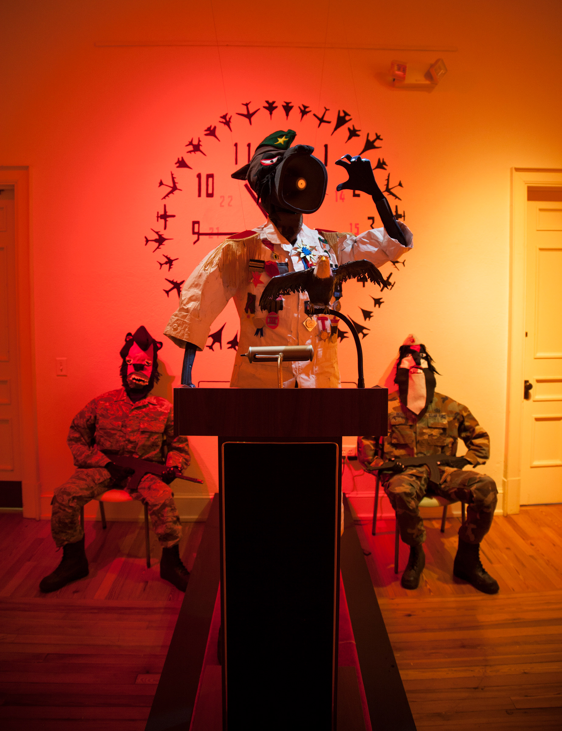 The General and his men is meant to represent the image of the president of the US giving speeches with the VP and Speaker of the House sitting directly behind. The general has a bullhorn for a mouth and the audio he broadcast is audio I collaged together from the documentary 'Basic Training' by Frederick Wiseman