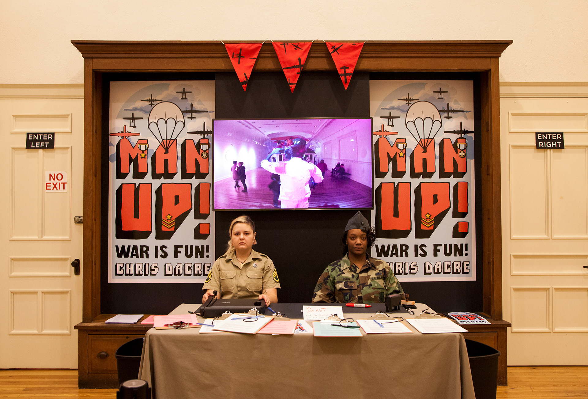 MAN UP!, Marketview Arts Gallery, York, PA. The TV monitor hung above the processing table was connected to a security camera inside the gallery space so the people getting ready to enter the gallery could surveil the people already inside 