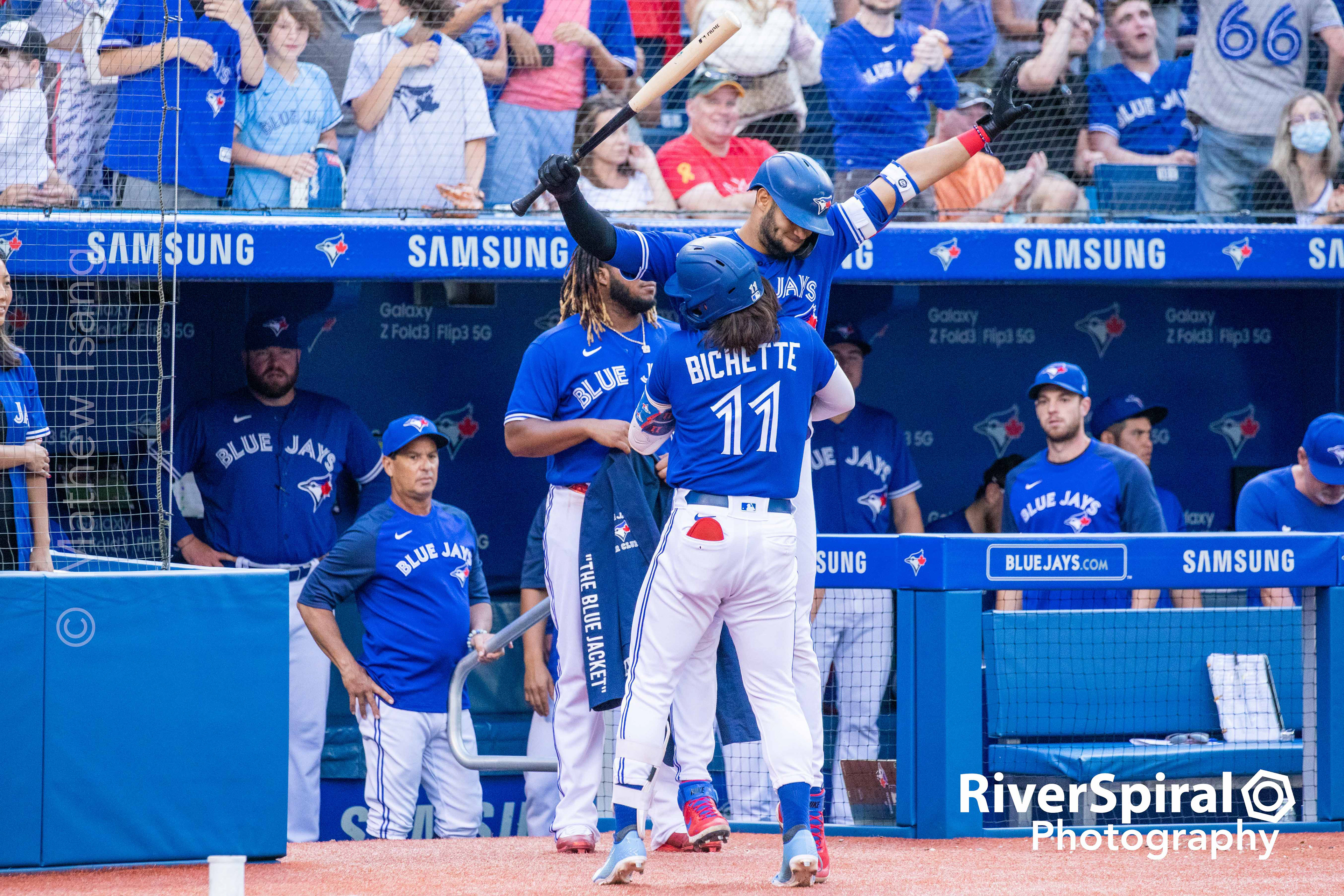 Bo Bichette (11) lifts teammate Lordes Gurriel Jr. (13).