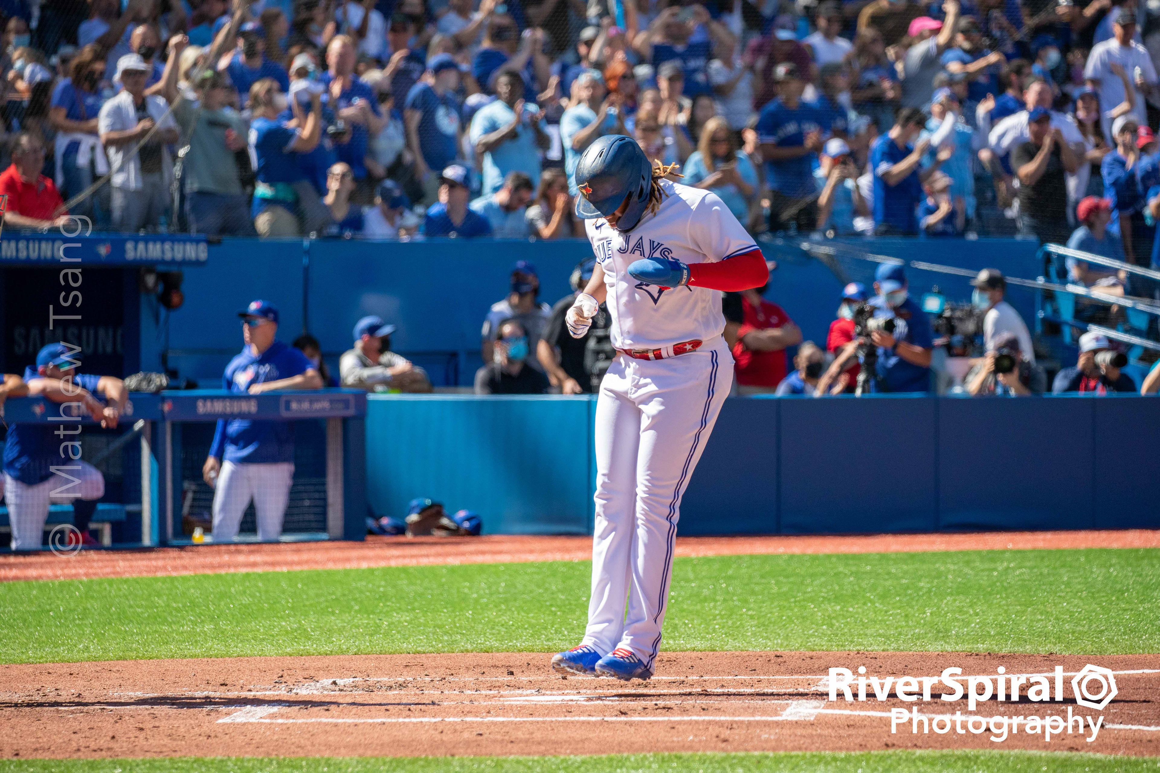 Vladimir Guerrero Jr. (27) leaps on to home plate.