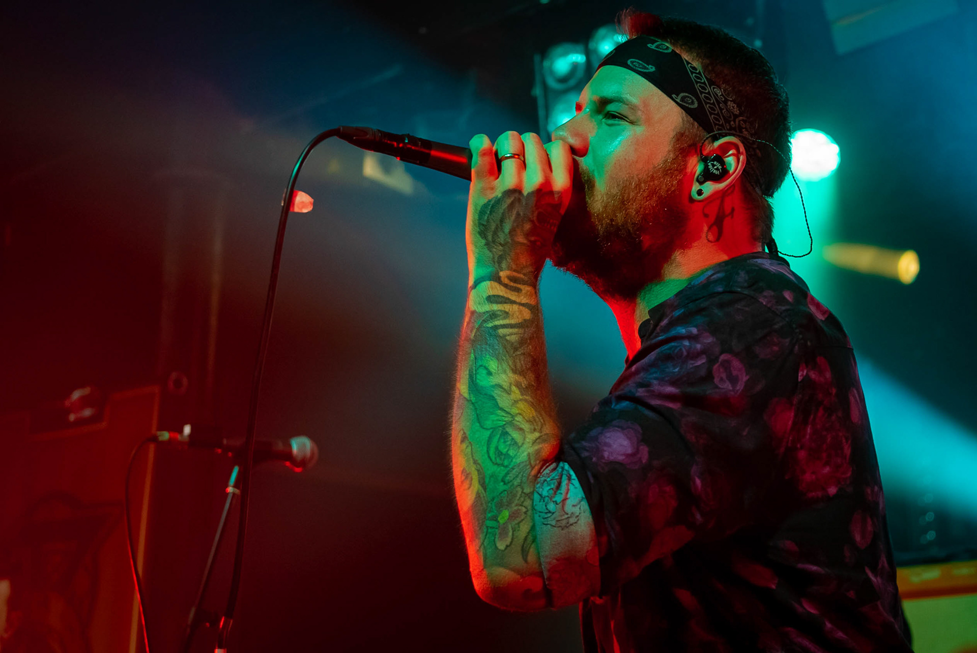 The singer of Beartooth holding a microphone performing on stage.