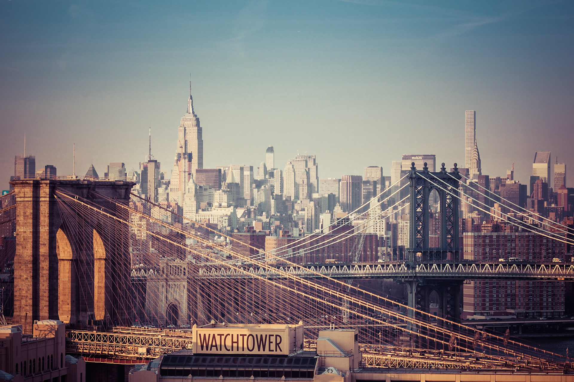 The late winter sun sets over Brooklyn and Manhattan, lighting the structures of stone and steel.