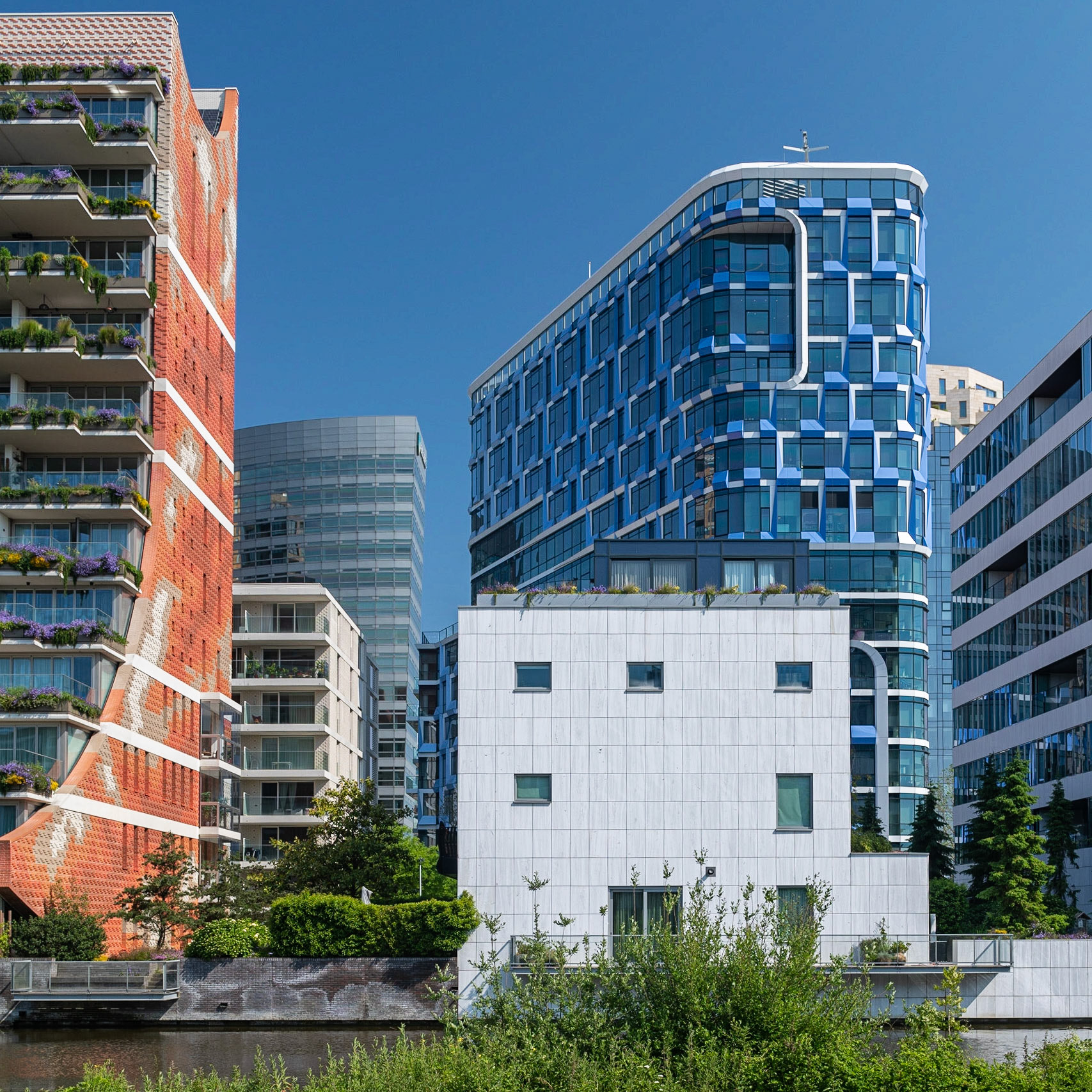 Amsterdam. Zuidas. De Amsterdamse Zuidas heeft enerzijds als doel om ontwikkeld te worden als internationaal businessdistrict waarin wordt voorzien in nieuwe bedrijfseconomische clusters en anderzijds te groeien als levendige nieuwe stadswijk waar wonen, werken en recreëren samenkomen.