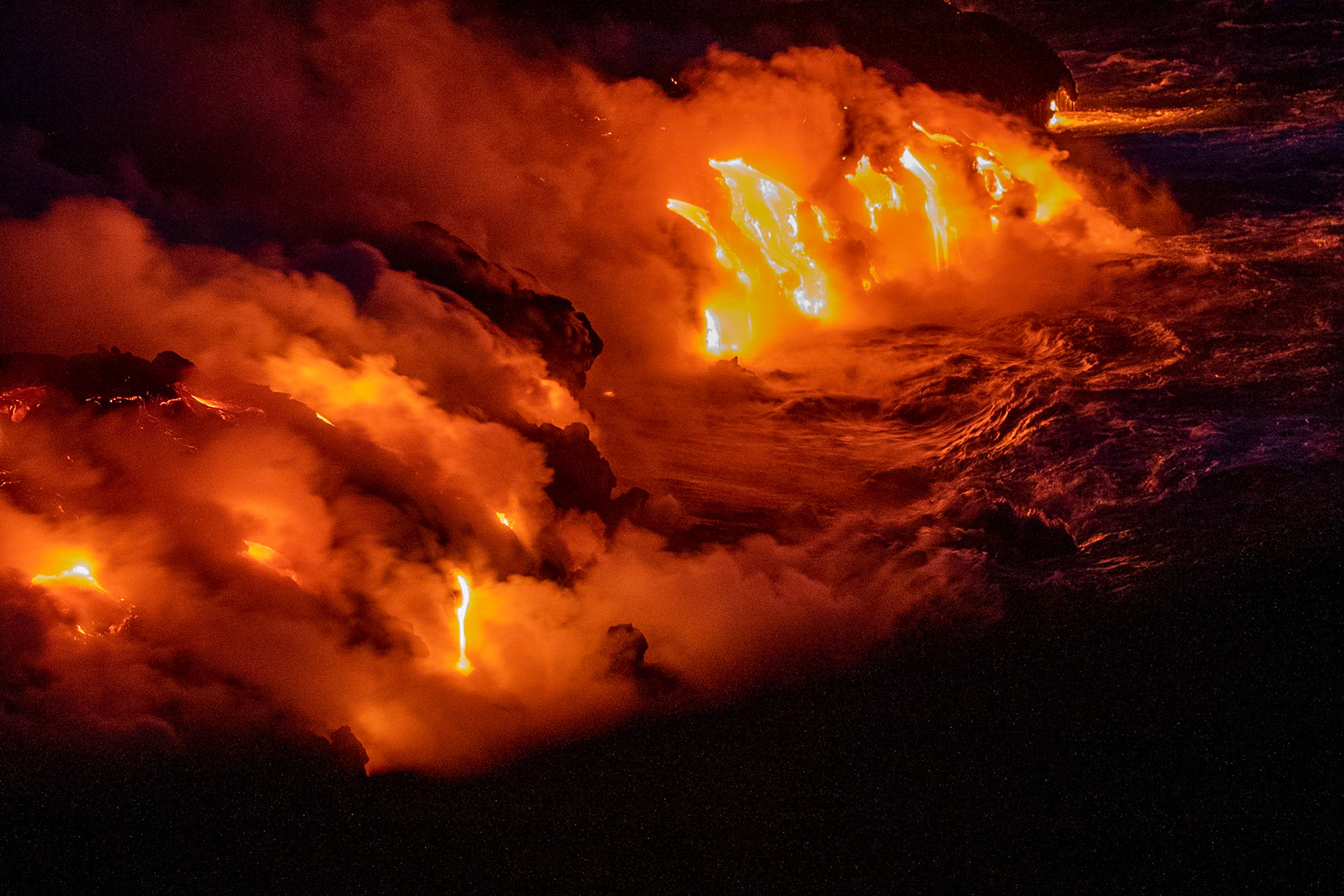 coulée de lave se jettant dans la mer fumeroles  de nuit lava flow to the sea fumes at night