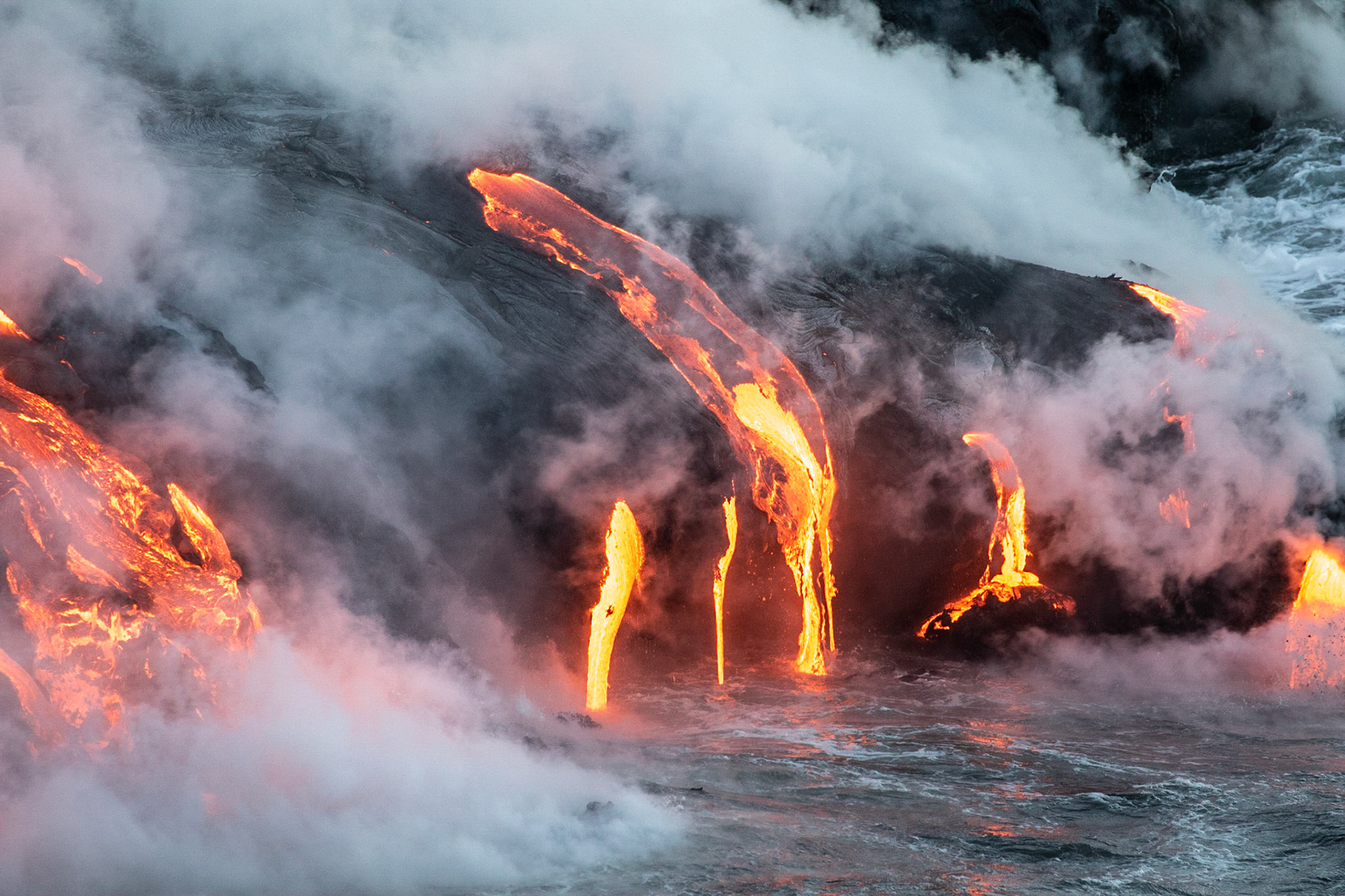 coulée de lave se jettant dans la mer fumeroles  de nuit lava flow to the sea fumes at night