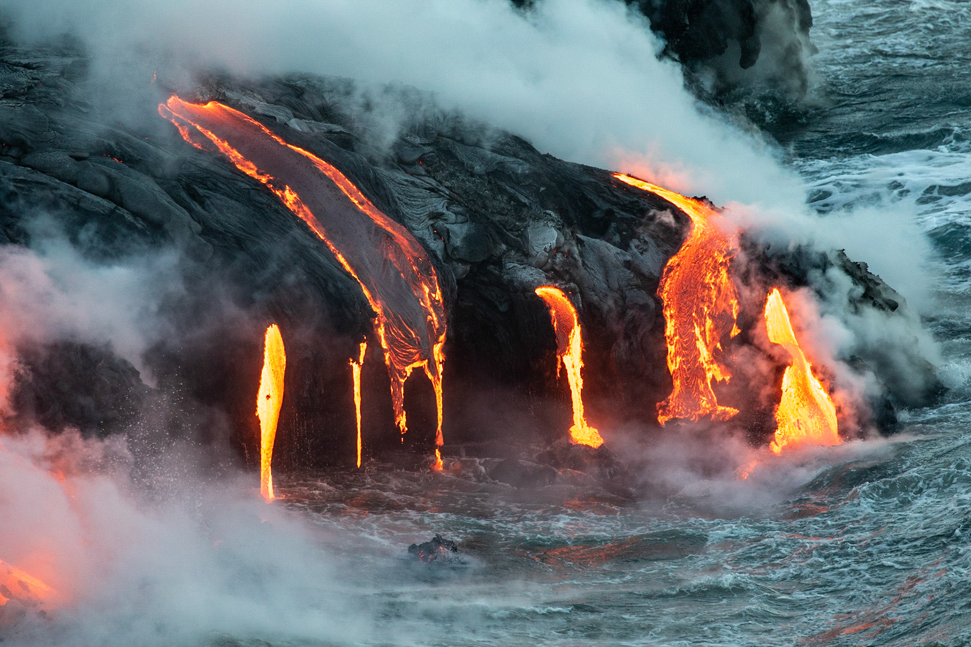 coulée de lave se jettant dans la mer fumeroles  de nuit lava flow to the sea fumes at night