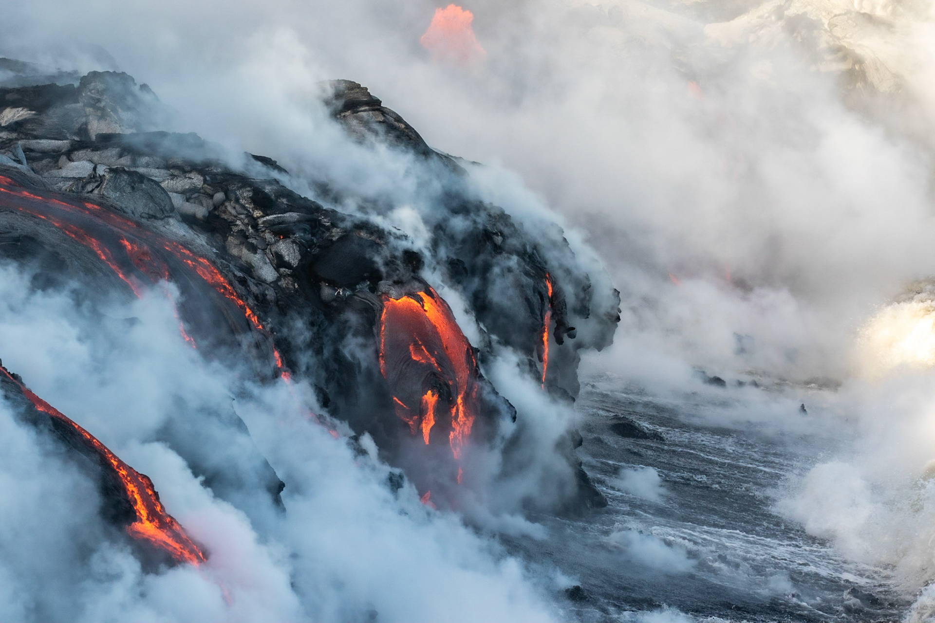 coulée de lave se jettant dans la mer fumeroles lava flow to the sea fumes