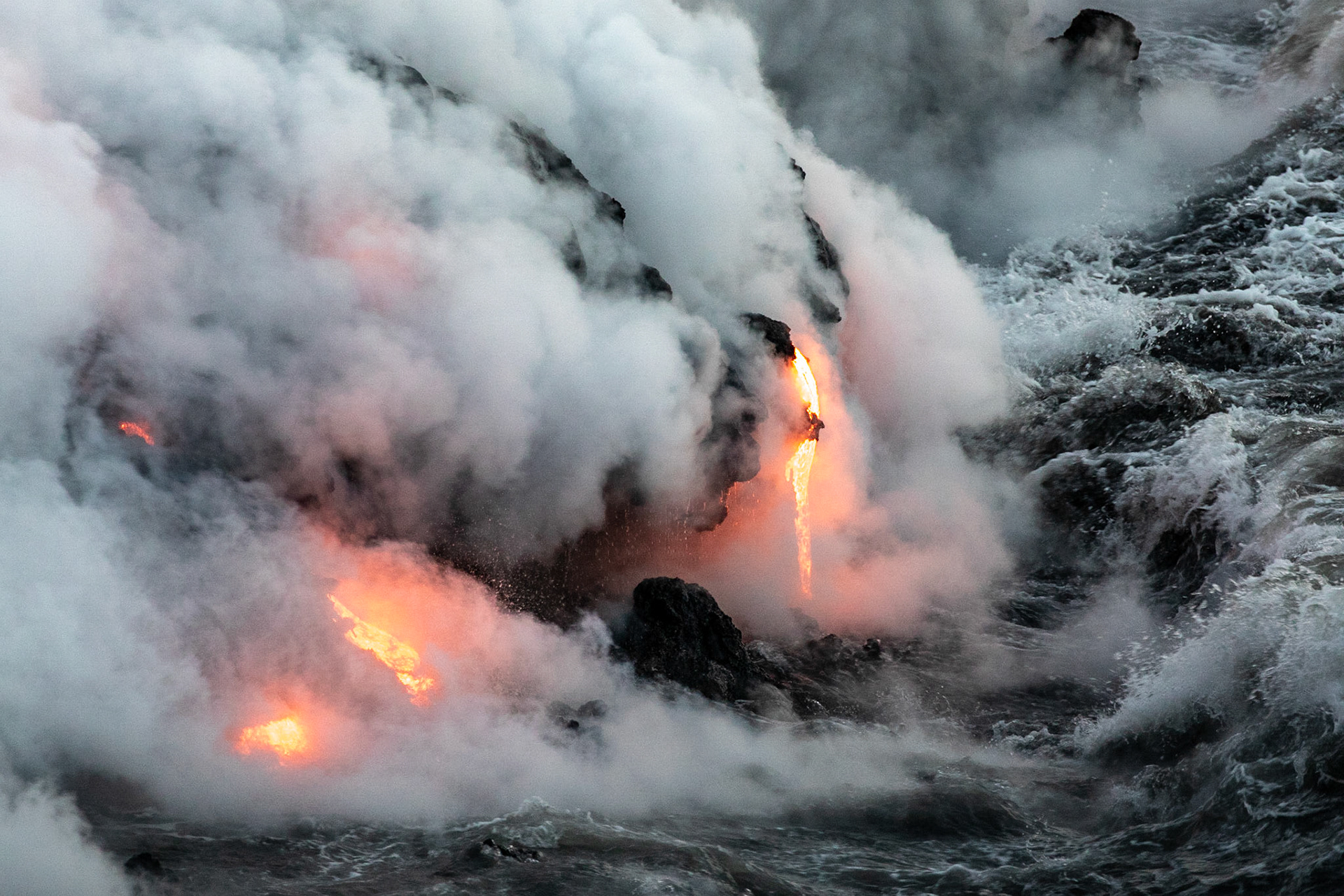 coulée de lave se jettant dans la mer fumeroles  de nuit lava flow to the sea fumes at night