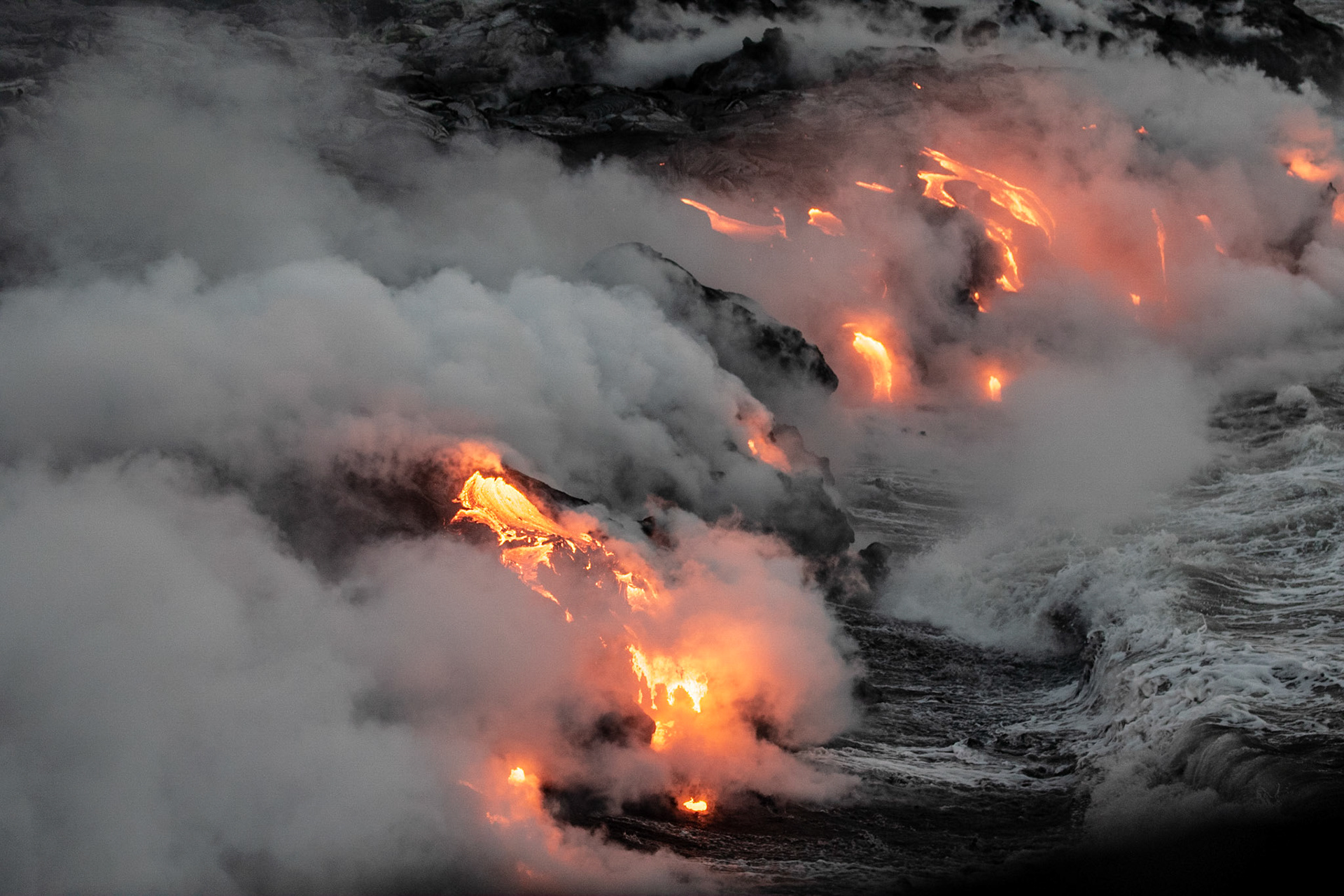 coulée de lave se jettant dans la mer fumeroles  de nuit lava flow to the sea fumes at night