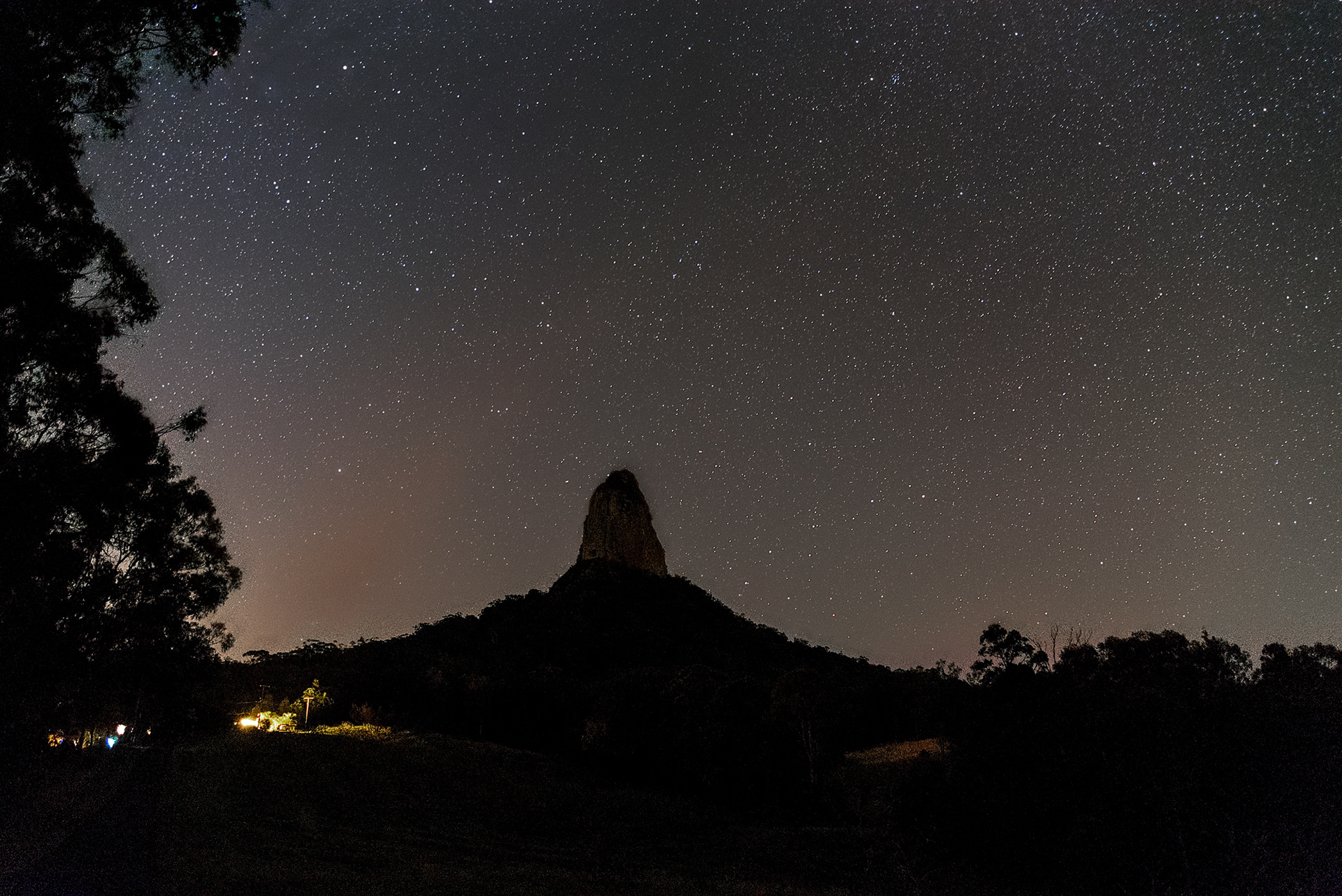The Mt Coonowrin volcanic plug towers over the surrounding Glass House Mountains National Park underneath the night sky
